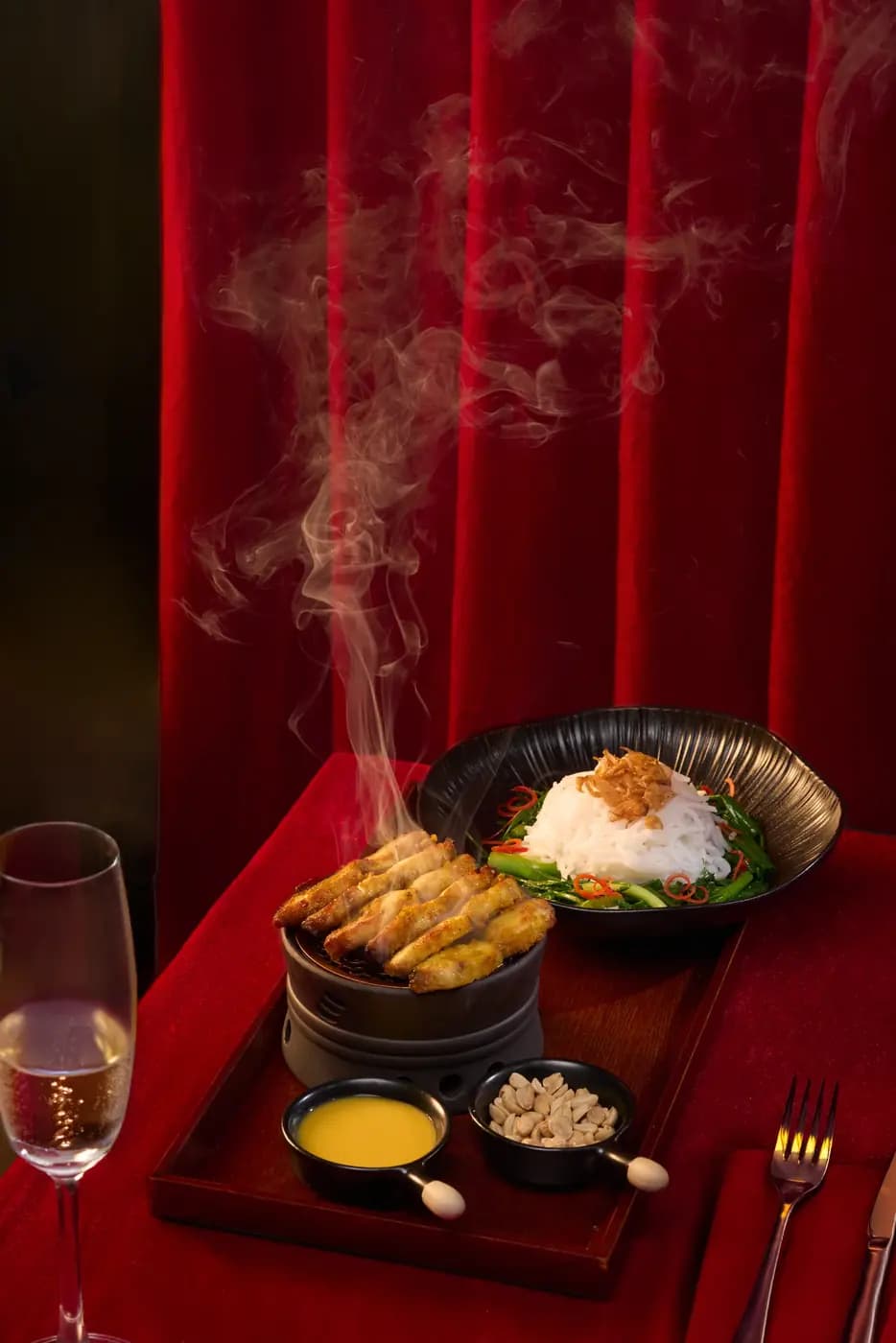Khay món ăn bốc khói và ly rượu trên bàn đỏ, Moulin de Da Nang