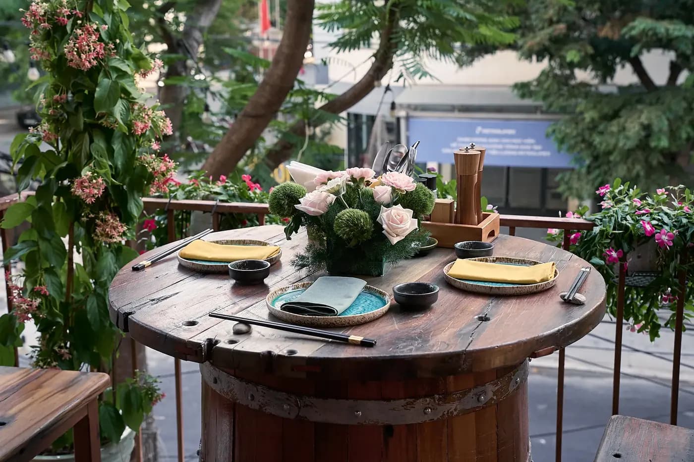 Bàn tròn gỗ bày sẵn trên ban công đầy hoa, Puro House