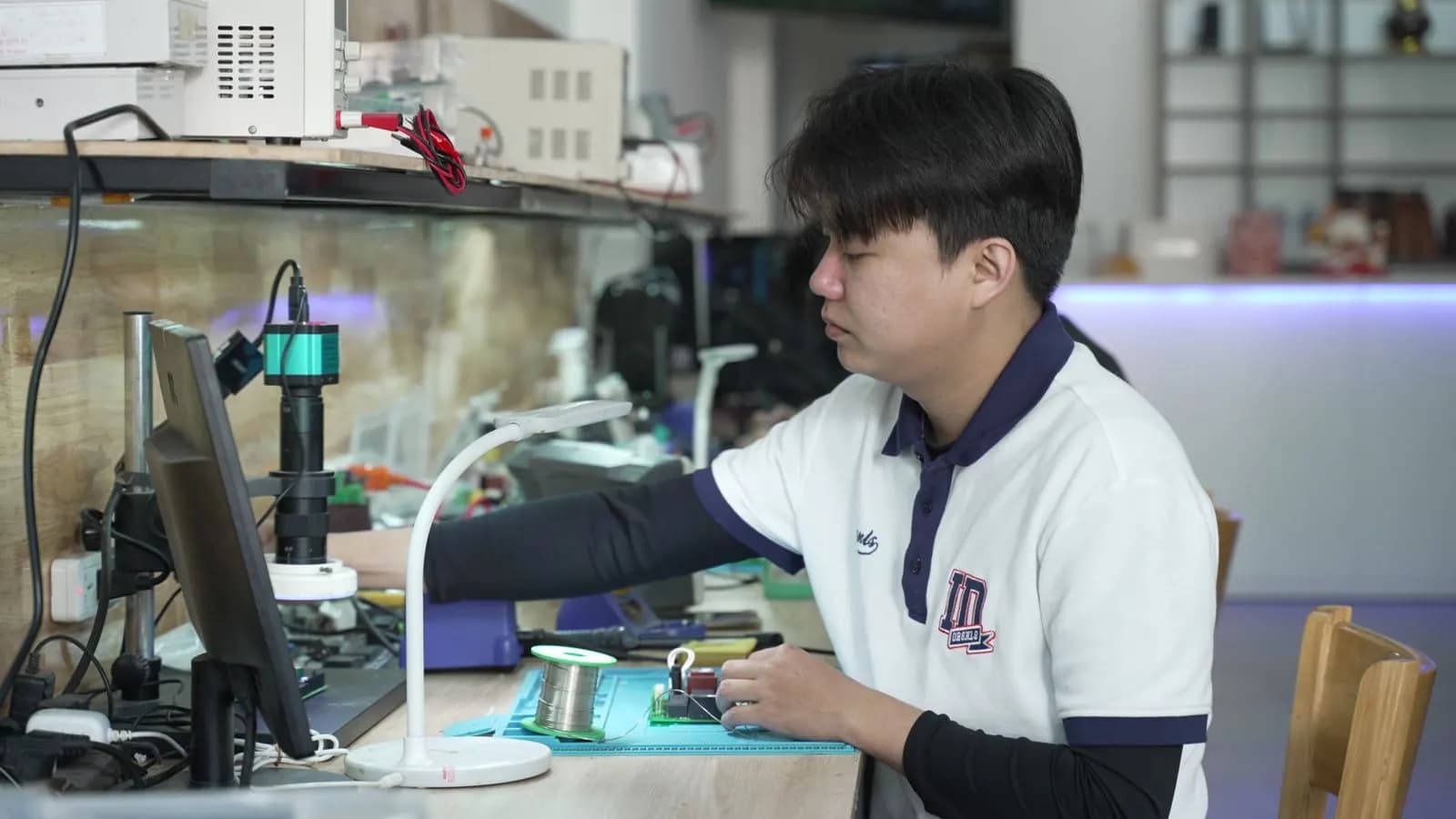 Kỹ thuật viên thao tác dưới kính hiển vi tại xưởng